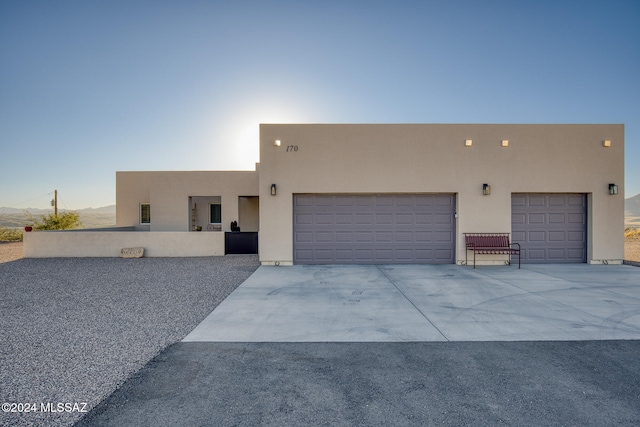 pueblo revival-style home with a garage