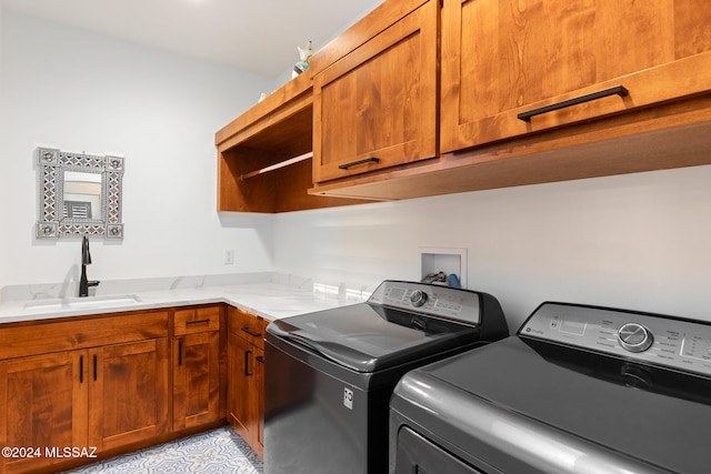 laundry room with cabinets, sink, and washer and clothes dryer