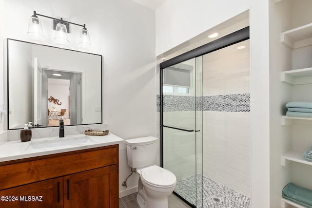 bathroom featuring toilet, vanity, and walk in shower