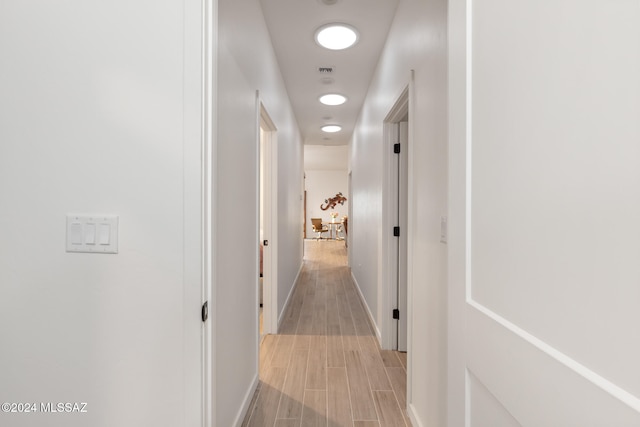 hallway with light hardwood / wood-style floors