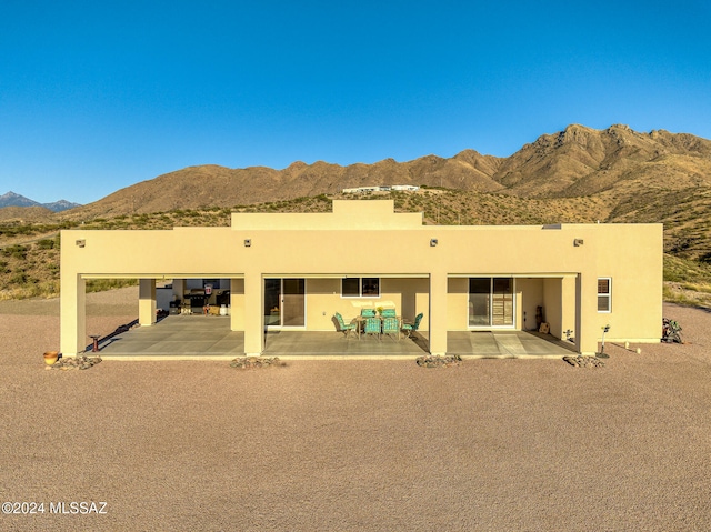 back of house with a mountain view and a patio