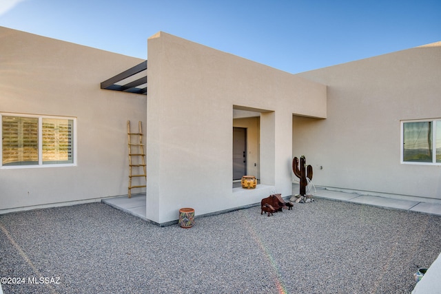 view of exterior entry with a patio