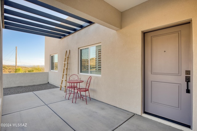 view of exterior entry with a patio area