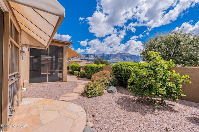 view of yard with a mountain view, a sunroom, and a patio