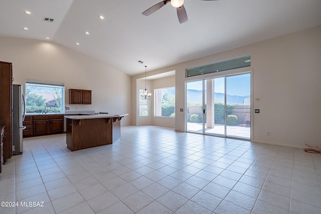 kitchen with a kitchen breakfast bar, vaulted ceiling, stainless steel refrigerator, pendant lighting, and a mountain view