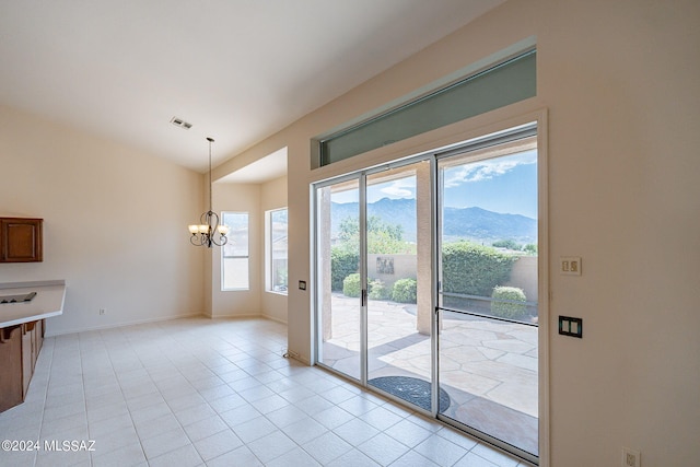 doorway with a mountain view, an inviting chandelier, and light tile patterned flooring