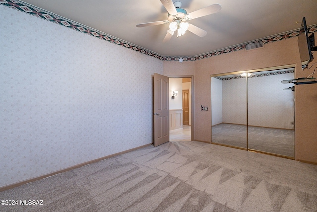 unfurnished bedroom with ceiling fan, light colored carpet, and a closet