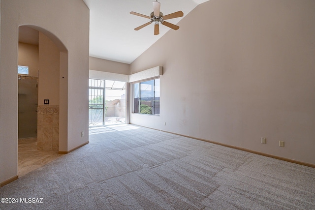 spare room with ceiling fan, light colored carpet, and high vaulted ceiling