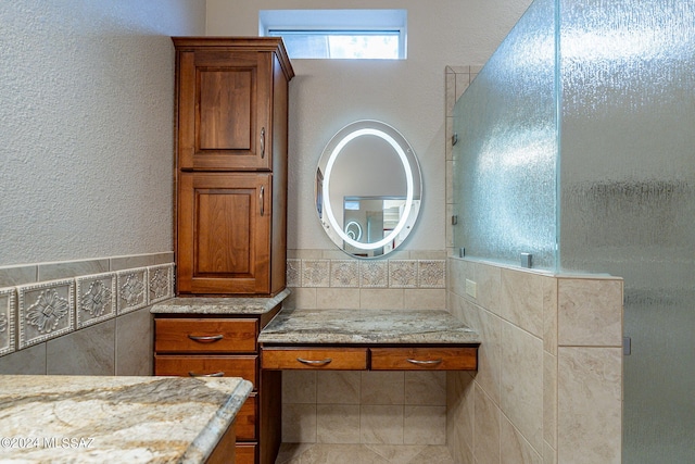 bathroom with vanity and tile walls