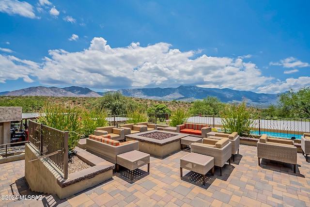 view of patio with a mountain view and an outdoor living space with a fire pit