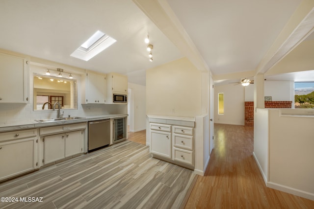 kitchen featuring decorative backsplash, stainless steel appliances, ceiling fan, sink, and light hardwood / wood-style flooring