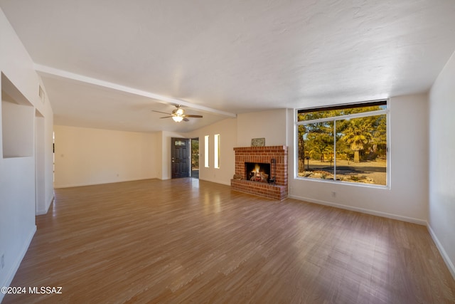 unfurnished living room featuring hardwood / wood-style floors, a brick fireplace, and ceiling fan