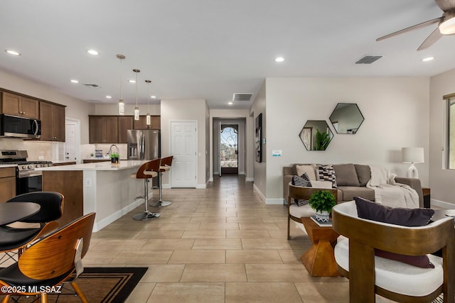 living room featuring ceiling fan, visible vents, and recessed lighting