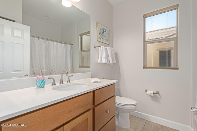 full bathroom featuring a shower with shower curtain, toilet, vanity, tile patterned flooring, and baseboards