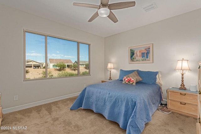 bedroom with multiple windows, light carpet, and ceiling fan