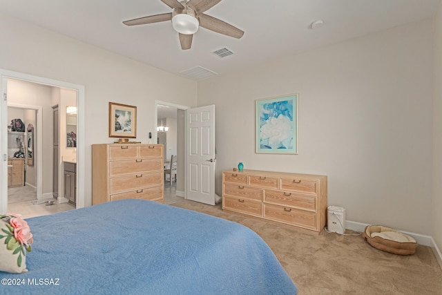 carpeted bedroom with ensuite bath and ceiling fan