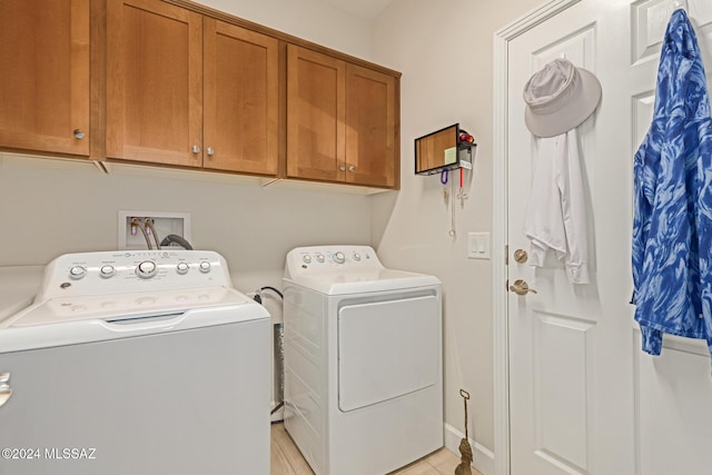 laundry area with separate washer and dryer and cabinet space