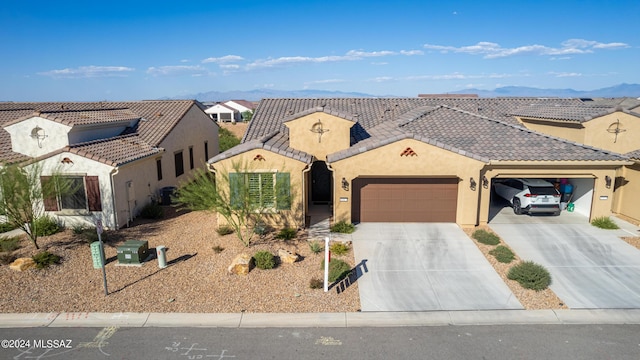 mediterranean / spanish-style home with a tile roof, stucco siding, concrete driveway, a garage, and cooling unit