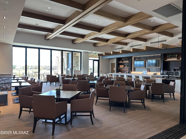 dining area featuring beamed ceiling, coffered ceiling, wood finished floors, and visible vents