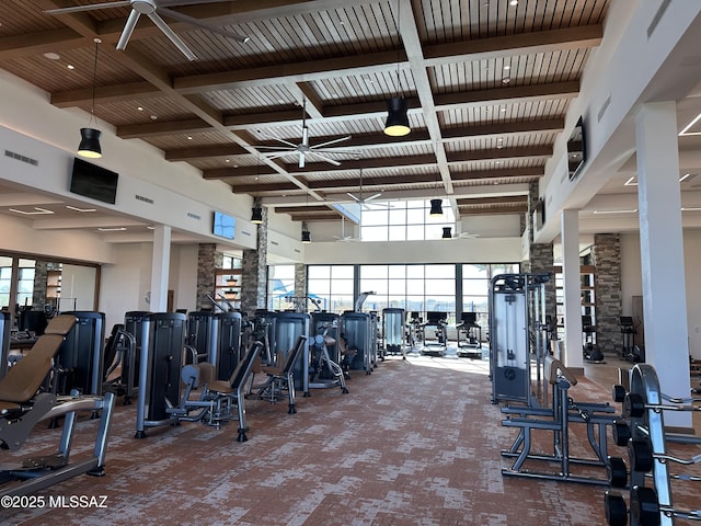 workout area with a ceiling fan, wooden ceiling, visible vents, and a high ceiling