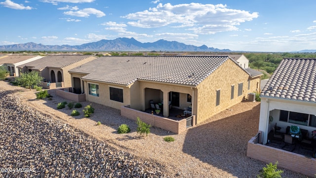 back of house with cooling unit, a mountain view, and a patio area