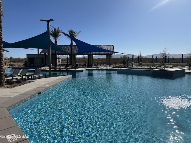 pool with fence, a mountain view, and a patio