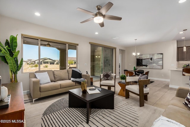 living room with recessed lighting, baseboards, and ceiling fan with notable chandelier