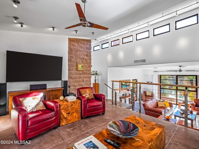 living area featuring a ceiling fan and a towering ceiling