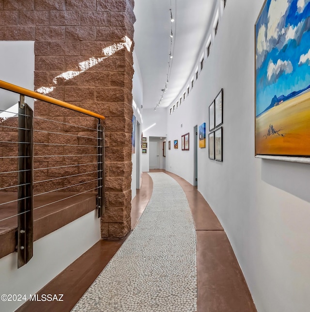 corridor with rail lighting and a high ceiling