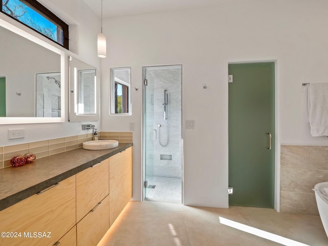 bathroom with a stall shower, vanity, tile patterned floors, and a freestanding bath