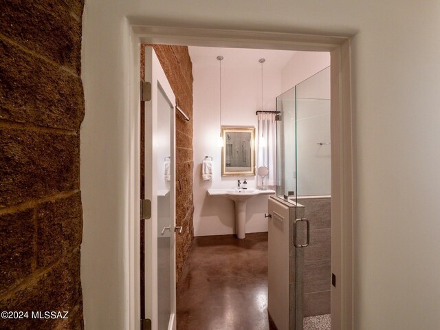 full bathroom with a stall shower and finished concrete floors
