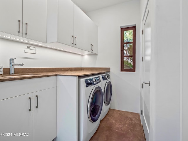 laundry area featuring washer and dryer, cabinets, and sink