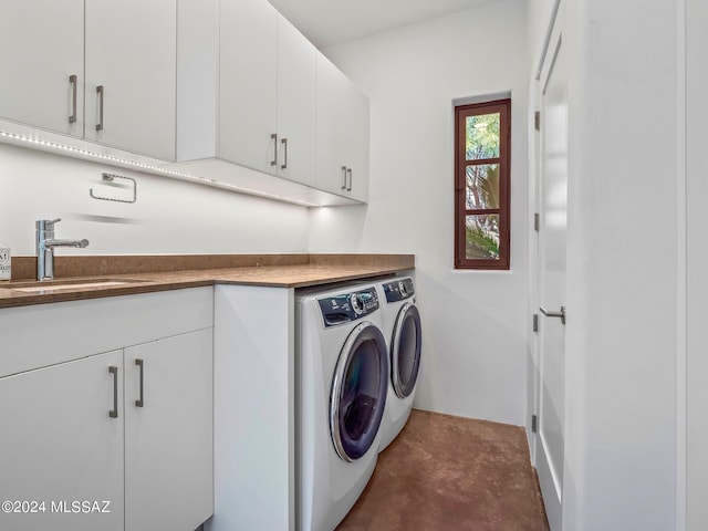 laundry room featuring separate washer and dryer and cabinet space
