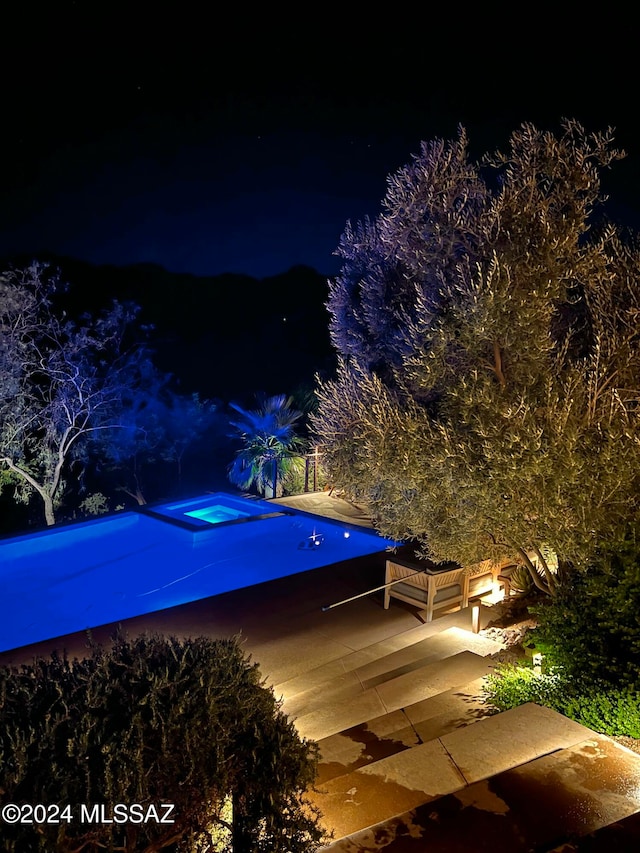 pool at twilight with a patio