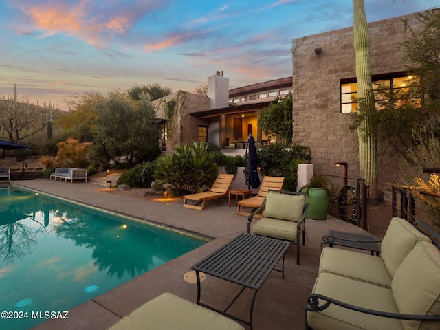 pool at dusk with a patio