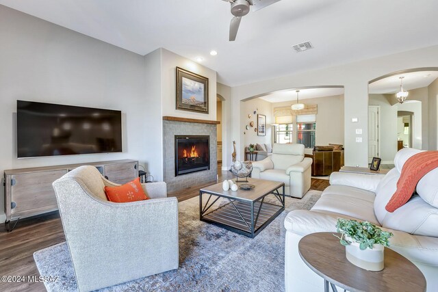 living room featuring a fireplace, wood-type flooring, and ceiling fan