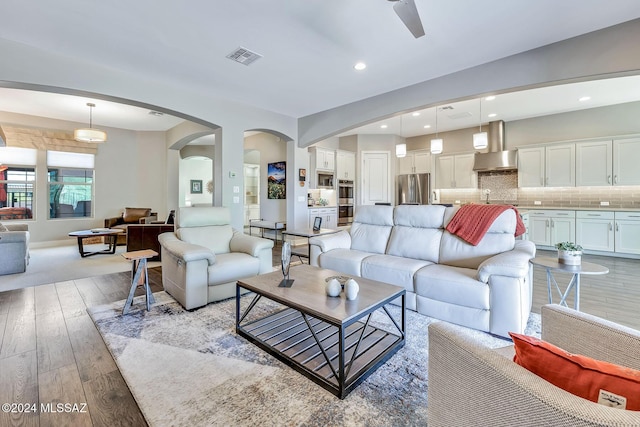 living room featuring light hardwood / wood-style flooring, ceiling fan, and sink