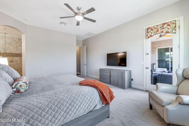 bedroom featuring ceiling fan, light colored carpet, and connected bathroom