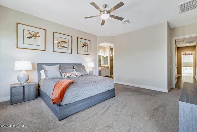 carpeted bedroom featuring ceiling fan and ensuite bath