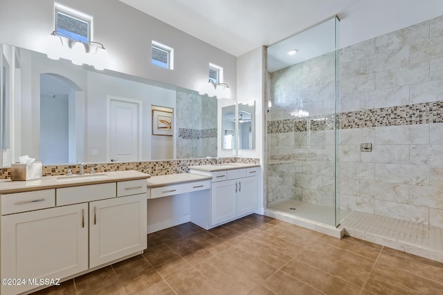 bathroom featuring tile patterned floors, decorative backsplash, vanity, and tiled shower