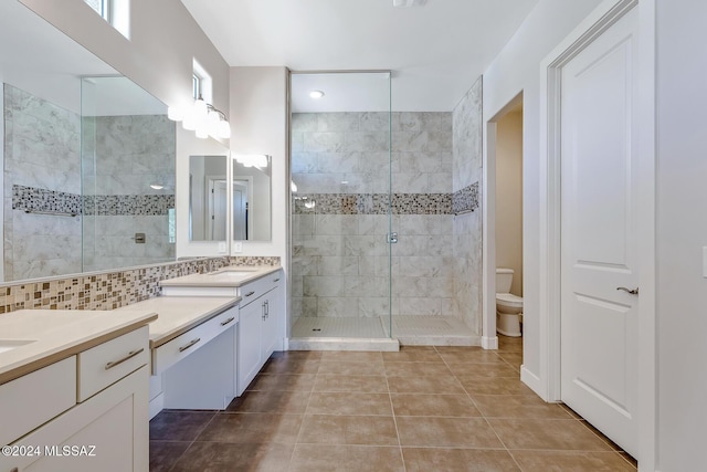 bathroom with decorative backsplash, vanity, tiled shower, tile patterned flooring, and toilet