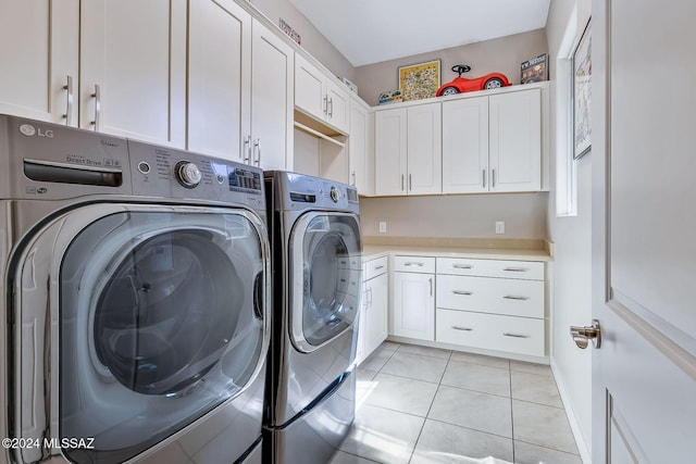 washroom featuring cabinets, light tile patterned flooring, and washer and dryer