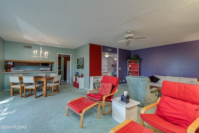 living area featuring sink, a textured ceiling, light colored carpet, and ceiling fan with notable chandelier