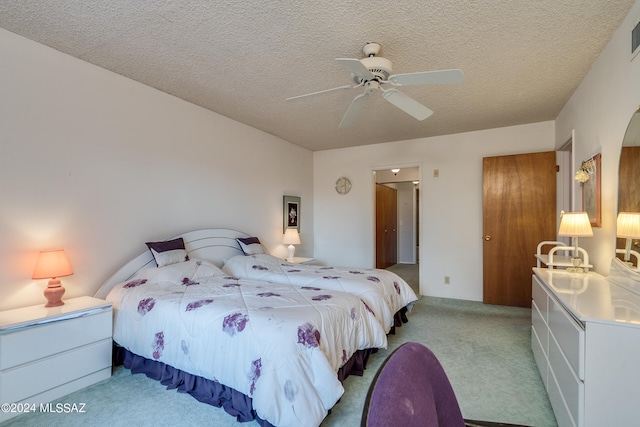 carpeted bedroom with a textured ceiling and ceiling fan