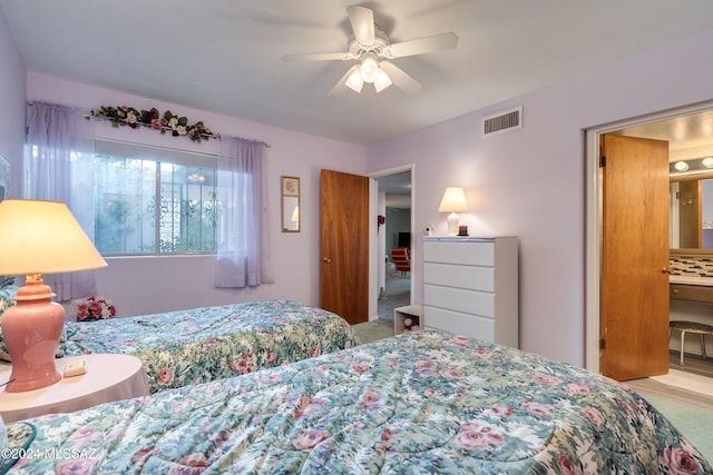 bedroom with ceiling fan, ensuite bathroom, and carpet floors