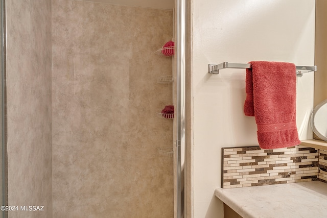 bathroom with vanity, decorative backsplash, and a shower with shower door