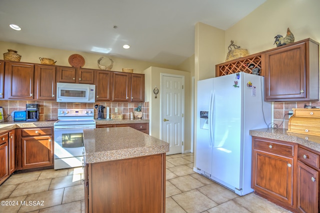 kitchen with decorative backsplash, white appliances, a center island, and light stone countertops