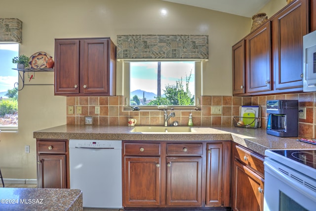 kitchen with white appliances, lofted ceiling, sink, and a wealth of natural light