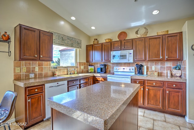 kitchen featuring sink, white appliances, backsplash, a center island, and vaulted ceiling