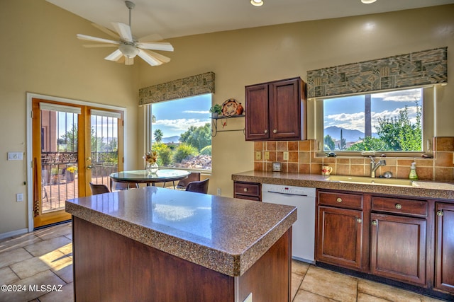 kitchen featuring white dishwasher, a center island, plenty of natural light, and backsplash